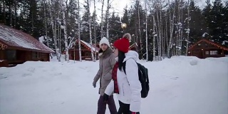 两个女人走过令人惊叹的冬季环境，相机稳定拍摄