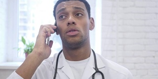 非裔美国医生在医院用智能手机讲话