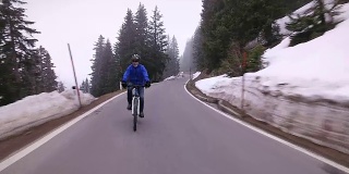老年人在冬季的山路上骑车