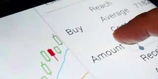 一个手机屏幕的特写与股票交易所的市场交易数据。