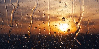 美丽的日出，同时下雨。在窗户后面看日出。4 k