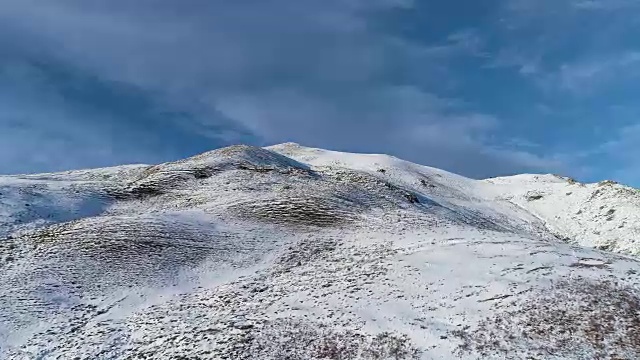 向前鸟瞰冬季雪山山顶在晴朗的日子与云和蓝色的天空。白阿尔卑斯山雪季的缔造者。达到峰值。4k无人机飞行建立镜头