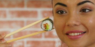 亚洲女人拿着寿司的特写