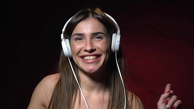 Sexy brunette in white headphones dancing and smiling