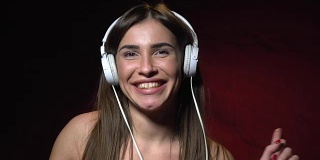 Sexy brunette in white headphones dancing and smiling