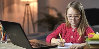 可爱的小女孩在家里用笔记本电脑在线学习