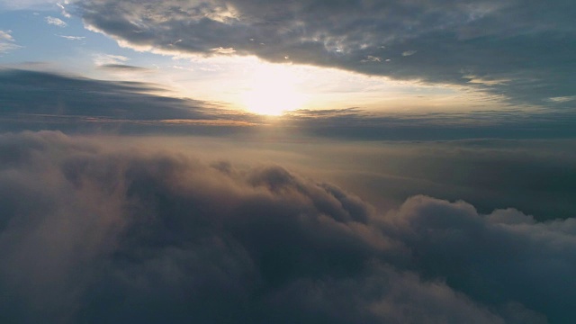 在日出时，在浓重的灰色乌云中向前飞行。空中延时运动。无人机hyperlapse。