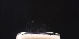 气泡可乐在一个玻璃喷射气体在一个黑色的背景。近距离