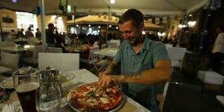 快乐饥饿的游客终于得到了他的披萨，并在吃前欣赏它的气味