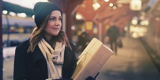 女人在火车站拿圣诞礼物的Cinemagraph