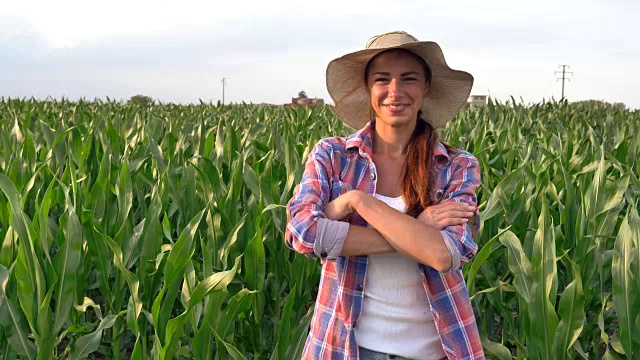 美丽的农家姑娘(女)面带微笑地看着葡萄田，手里拿着一块黑色的木板，穿着一件衬衫，戴着一顶草帽。概念生态，酒生物产品检验，水自然产品农业