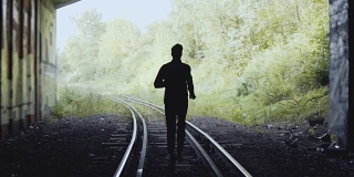 缓慢的运动。一个人在铁路上向前跑。后视图。抽象的轮廓。追随梦想的概念