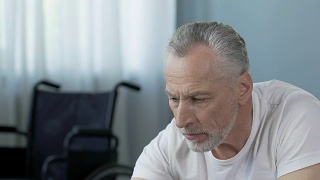 老人吃药，站在轮椅上，接受康复治疗视频素材模板下载
