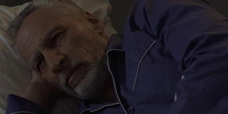 长胡子的老人躺在床上无法入睡，晚上失眠