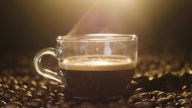 俯视图一杯意大利咖啡在木质背景与咖啡豆被磨碎。上等的咖啡，热气腾腾的。概念:放松、芳香和香水。