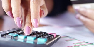 商务妇女手计算计算器使用她的信用卡在网上购物