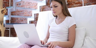 年轻女子在笔记本电脑上工作时因失落而心烦意乱