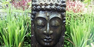 在巴厘岛乌布的热带花园中，佛陀与落水。