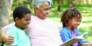 奶奶和孩子们一起在户外看书。