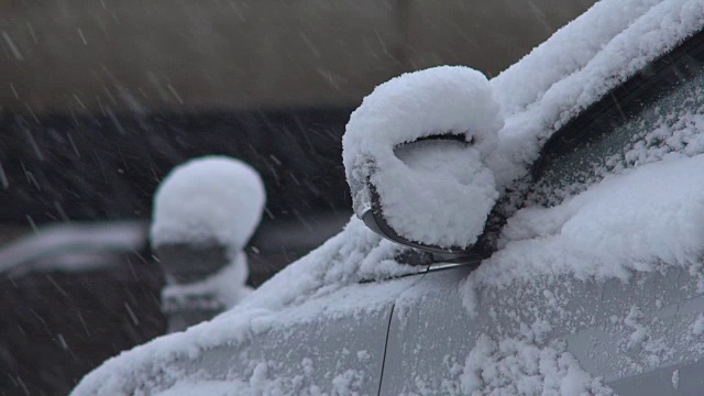 冬天。下雪时，汽车在城市的道路上行驶。龙卷风期间的汽车交通。特写镜头