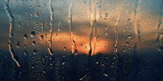 美丽的日出，同时下雨。在窗户后面看日出。4 k
