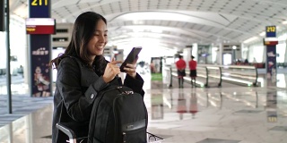 亚洲女性在机场候机楼和离境区使用智能手机