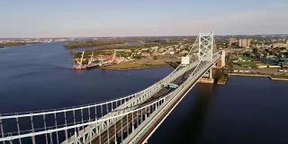 hyper-lapse。无人机鸟瞰图的本杰明富兰克林桥横跨德拉瓦河从费城，宾夕法尼亚州卡德门，新泽西州