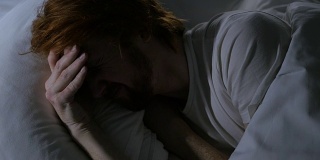 头痛，忧郁的男人睡在黑暗的房间的床上