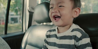 亚洲小男孩乘坐家庭汽车旅行