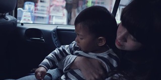 年轻的亚洲母亲带着男婴开车旅行。