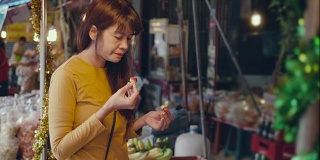 亚洲妇女在市场买草莓