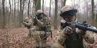 一群年轻的武装士兵在一个地区的武装冲突中穿着制服以突击步枪瞄准森林，慢镜头，软式