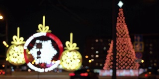 圣诞树在夜晚城市冬天积雪覆盖的道路上闪闪发光，在交通堵塞的车辆中驶过，概念圣诞夜，新年，雪花，吹暴风雪，汽车覆盖的雪，雪花在车灯