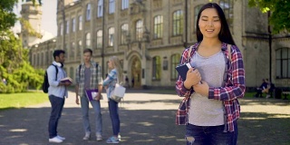 可爱的亚洲女孩摆姿势附近的大学大楼，国际教育项目