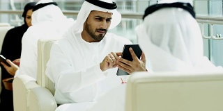阿联酋的男性女性企业高管使用平板电脑开会
