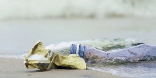 塑料瓶和旅游船上的垃圾在海岸被污染的水冲洗