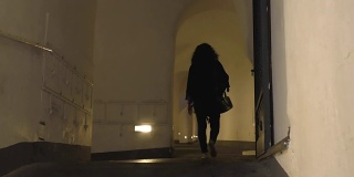 晚上一个女人在狭窄的过道上行走