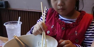 两个亚洲小孩在餐厅吃饭。