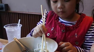 两个亚洲小孩在餐厅吃饭。视频素材模板下载