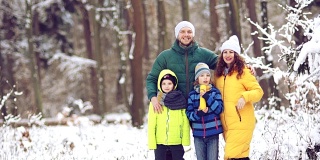 一个年轻的家庭在森林度假的肖像。明亮的运动服，积极的生活方式