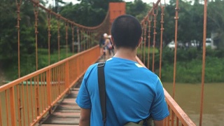 ้泰国男子在万荣的一座橙色桥上行走视频素材模板下载
