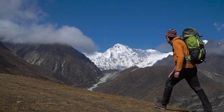 一个背着背包的男人爬上了喜马拉雅山的山坡