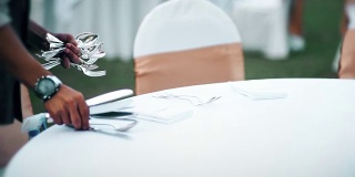 餐厅员工为宴会或婚宴设置户外餐桌。