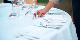 餐厅员工为宴会或婚宴设置户外餐桌。