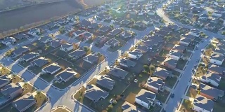 阳光和房地产市场爆炸的无人机拍摄的郊区社区，完美的小盒子房子在完美的排