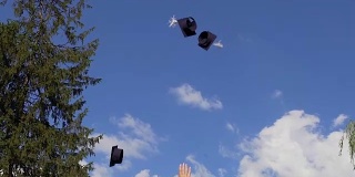 兴高采烈的学生们把毕业帽抛向空中，为学习结束而高兴