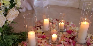 玫瑰花瓣间的玻璃瓶里的蜡烛。婚礼