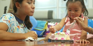 小女孩和家人一起吃生日蛋糕