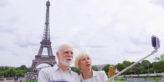 一对老夫妇在埃菲尔铁塔附近自拍。在欧洲旅游。退休后活跃的现代生活