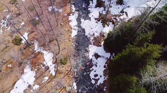 空中飞行，飞越黄山河溪和森林秋季的建立。秋冬户外雪野自然景观。4k无人机俯视图，直接向下视角建立拍摄
